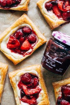 strawberry shortbreads with jam on the side and some sliced strawberries in the middle