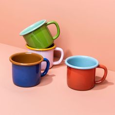 three different colored mugs sitting on top of each other