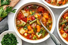 three bowls filled with vegetable soup on top of a table