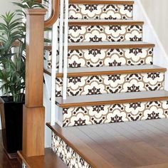 the stairs are decorated with black and white tile designs, along with a potted plant