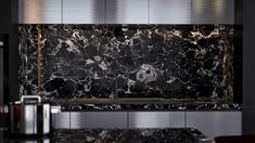 a black and white marble counter top in a kitchen with stainless steel appliances on the side