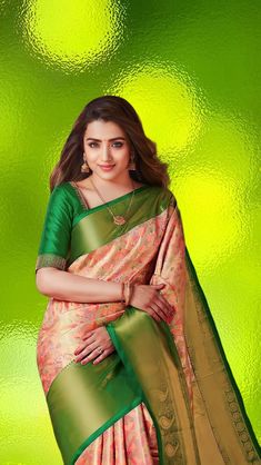 a woman in a green and pink sari with gold border on the blouse, posing for