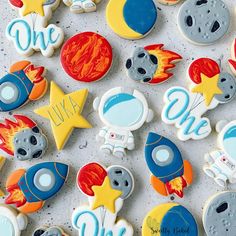 decorated cookies are arranged in the shape of rockets, stars and rocket ship on a white surface