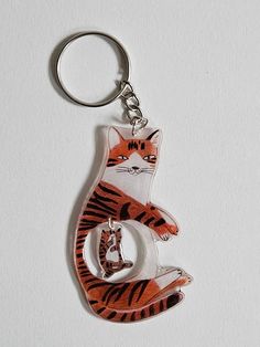 a keychain with a cat on it sitting in the shape of a letter g