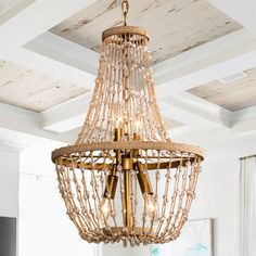 a chandelier hanging from the ceiling in a room with white walls and wood floors