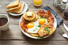 an english breakfast with eggs, bacon and toast on a plate next to a cup of coffee