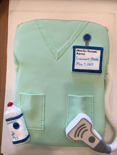 a cake shaped like a doctor's coat with a baby bottle on the side