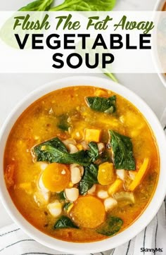 a bowl of vegetable soup with spinach and carrots in it on a table