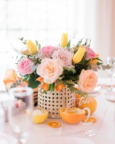 a vase filled with lots of flowers sitting on top of a table next to orange slices