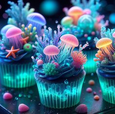 cupcakes decorated with jellyfish and sea creatures are displayed on a table top