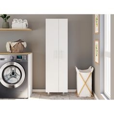 a washer sitting next to a tall white cabinet in a room with gray walls