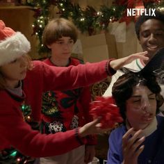 a group of people standing around each other in front of a christmas tree