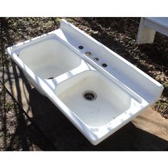 a white sink sitting on top of a tree stump