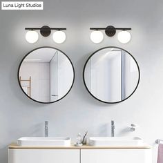 two round mirrors on the wall in a bathroom