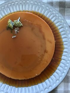 a plate topped with a dessert covered in caramel sauce and garnished with a leaf