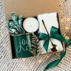 a box filled with candles and other holiday decorations next to a green ribbon tied around it