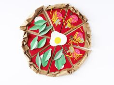 a paper plate that has some food on it with leaves and an egg in the middle