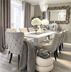 a dining room table with chairs and a mirror on the wall in front of it