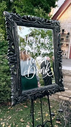 a large mirror sitting on top of a easel in front of a tree and grass