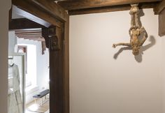 a wooden cross hanging on the wall next to a doorway in a room with white walls