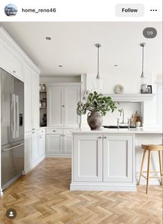 an image of a kitchen setting with white cabinets and wood flooring in the middle