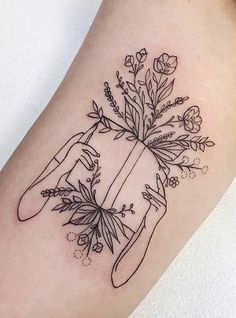 a woman's arm with flowers and scissors on it