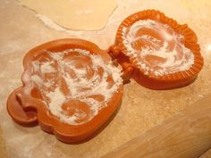 two cookie cutters sitting on top of a counter covered in icing and powdered sugar