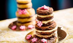 a stack of cookies sitting on top of a table next to each other covered in frosting