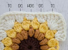 a crochet square with two rows of yellow and brown yarn in the center