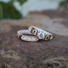 two wedding rings sitting on top of a rock