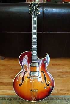 a guitar sitting on top of a wooden floor