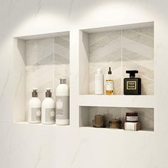 three shelves with bottles and soaps on them in a white tiled bathroom wall niche