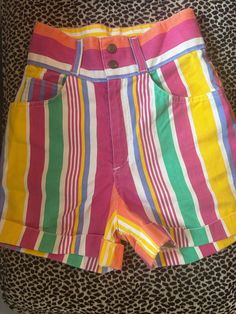 Vintage 1990's High Waisted Denim Shorts Vertical stripes  Yellow, white, pink, orange, purple, green, blue Zip and snap waist closure Great vintage condition- light wear, no flaws to note Measurements (in inches): Waist: 26 Length: 16 Hip: 35 90s Style Pink Cotton Bottoms, Pink High Waist 90s Bottoms, 90s High Waist Pink Bottoms, High Waist Pink 90s Bottoms, Retro Pink Shorts, Vibrant Multicolor High-waist Bottoms, Retro Pink Short Bottoms, Multicolor High-rise Bottoms With Pockets, Vibrant Multicolor High Waist Bottoms