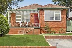 a brick house with green grass in the front yard