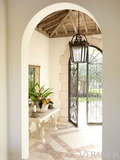 an archway leading to a patio with a bench and potted plant on the side