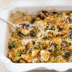 a casserole dish with broccoli, cheese and other toppings in it