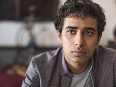 a close up of a person wearing a shirt and tie looking at the camera with a serious look on his face