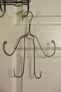 a coat rack hanging from the side of a door with two hooks on each hook