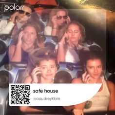 some people are sitting in a roller coaster talking on their cell phones and smiling at the camera