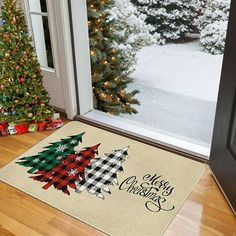 a christmas tree door mat sitting on top of a wooden floor next to a window