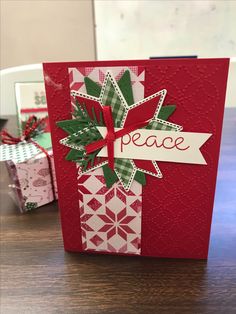 a red card with a green bow and peace on it, sitting on top of a table