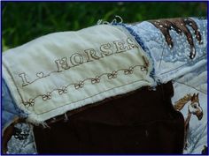 a close up of a patchwork horse pillow with the word i love horses on it