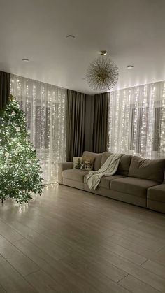 a living room with a christmas tree in the corner and lights on the wall behind it