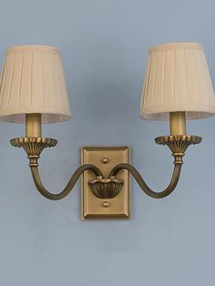 two lamps are attached to the wall with one light on it's side and the other is off