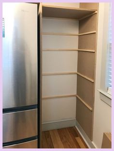 an empty pantry with shelves and a refrigerator