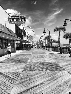 the boardwalk is lined with shops and palm trees