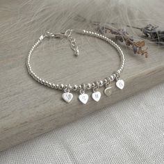 Christmas Gift For Mum Family Initials Bracelet in Sterling Silver, Minimalist silver bracelet and ideal Christmas Present for Her  Each family members initial, on each tiny heart, on this dainty and delicate looking beaded bracelet, perfect for mums and grandmas for Christmas Created in your size and letters, from sterling silver beads and hearts. Strung on Flexible wire. Extremely comfortable to wear, the little hearts do not get in the way at all and is ideal for those who don't tend to wear a lot as its so dainty How to measure: Measure the Wrist and add 0.5-1 inch Metal: Sterling Silver Size: 2mm beads. 5mm hearts Clasp: Lobster Clasp and ext. chain Packaging: Wrapped in Tissue, then nestled in a Branded Black Gift Box with care card. Dainty Sterling Silver Jewellery; Personalised wit Delicate Silver Chain Bracelet As Gift, Elegant Sterling Silver Beaded Bracelet With Heart Charm, Elegant Personalized Sterling Silver Beaded Bracelets, Minimalist Chain Bracelet With Charms As Gift, Mother's Day Sterling Silver Beaded Bracelet Gift, Sterling Silver Charm Bracelet With Initials In Silver, Heart-shaped Charm Bracelet For Personalized Gift, Nickel Free Silver Name Bracelet, Silver Dainty Bracelet For Valentine's Day