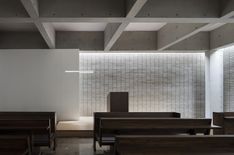 the interior of a church with pews and stained glass panels on the wall behind them