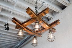 a chandelier made out of wooden planks with lights hanging from the ceiling