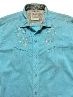 "Circa 1950s - 1960s ~ Vintage H Bar C Western Shirt ~ fits S  ~ Western style back yoke and \"smiley\" pockets ~ Rau \"Klikit\" snap buttons Color: Light blue with contrasting blue and silver embroidery. Fabric: Not tagged; either 100% cotton or a cotton/rayon or cotton/acetate blend. This one also has an embroidered \"jacquard\" style pattern woven in as well as the classic floral embroidery. Condition: Excellent overall. A faint spot on the front placket toward the very bottom of the shirt (won't be seen when the shirt is tucked in), a tiny spot on the lower back by the side seam (ink?), and a few other even less significant spots/marks that are hardly worth mentioning. The shirt presents beautifully. Size: Tagged 15 1/2 - 5. Seems to fit like a \"Small\". PLEASE OBSERVE THE MEASUREMENT Retro Embroidered Collared Top, Retro Collared Embroidered Top, Vintage Embroidered Summer Shirt, Retro Embroidered Summer Shirt, Retro Embroidered Button-up Top, Vintage Embroidered Button-up Shirt, Silver Embroidery, Western Vintage, Embroidery Fabric